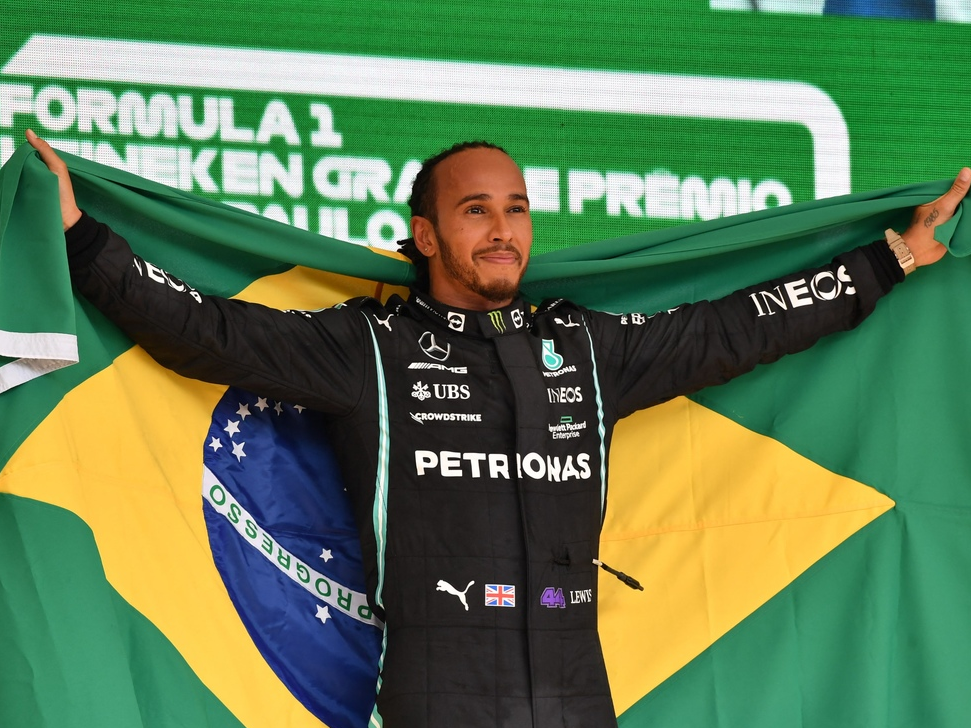 Hamilton repetiu um gesto de Ayrton Senna e finalizou a volta de comemoração com uma bandeira do Brasil, que também ergueu no pódio. Crédito: Fórmula 1