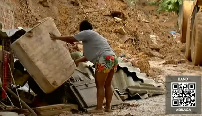 Moradora retira objetos danificados em enchente em Recife  Reprodução / TV Band