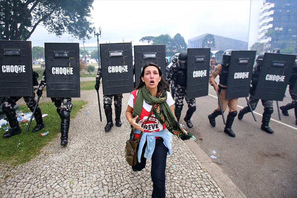 A professora Angela Alves Machado corre do Batalhão de Choque, em Curitiba. 29/04/2015 Daniel Castellano / arquivo / colaboração 