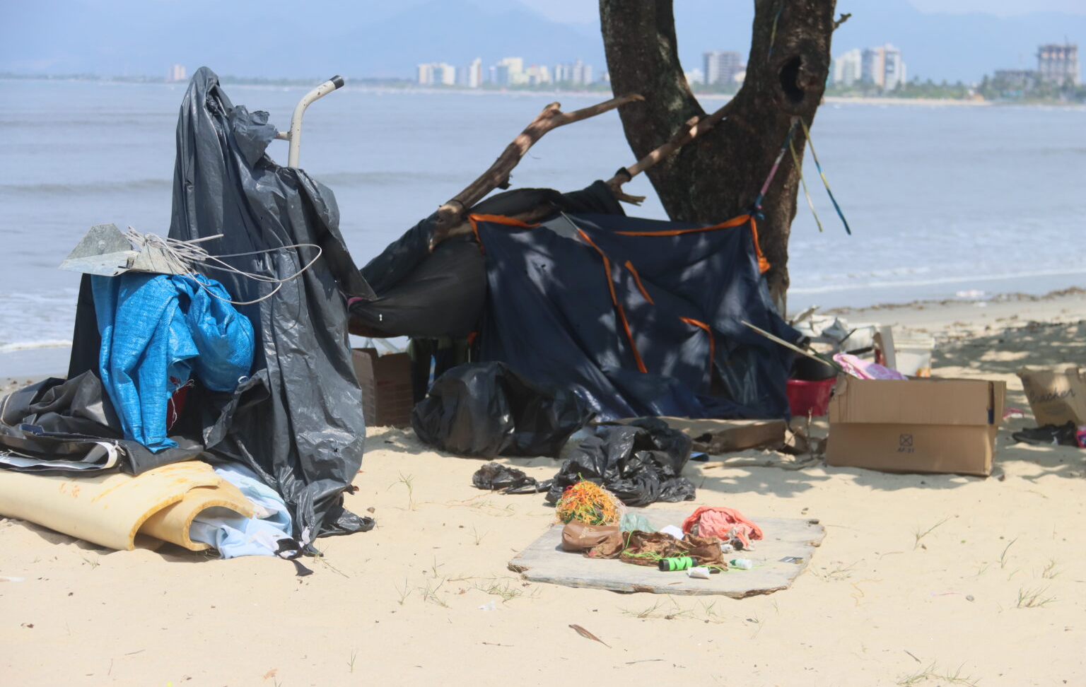  Barraca improvisada com lona e galhos de madeira montada na faixa de areia Divulgação/ PMC