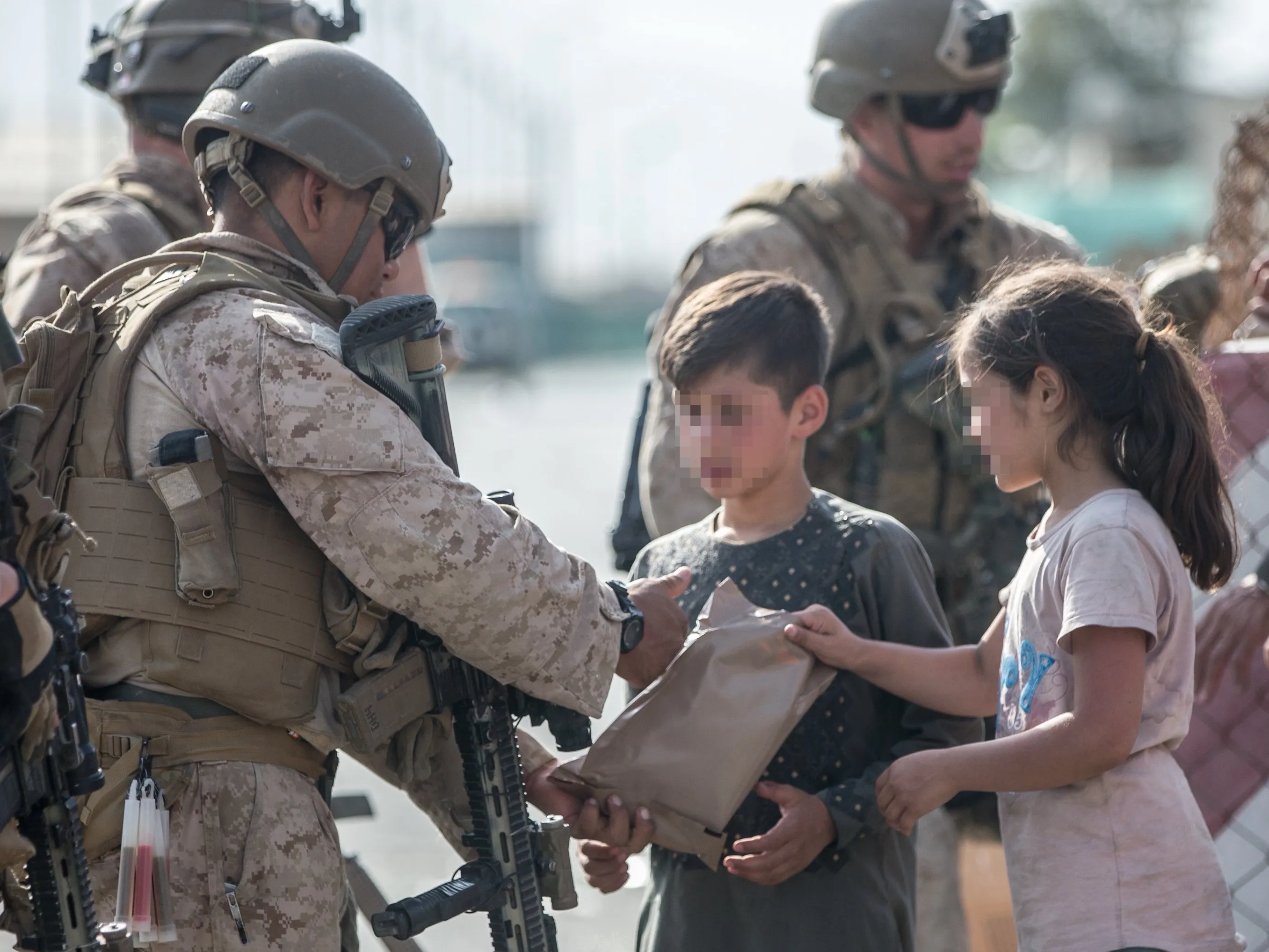 Soldados americanos no aeroporto de Cabul atendem crianças que esperam para deixar o Afeganistão.