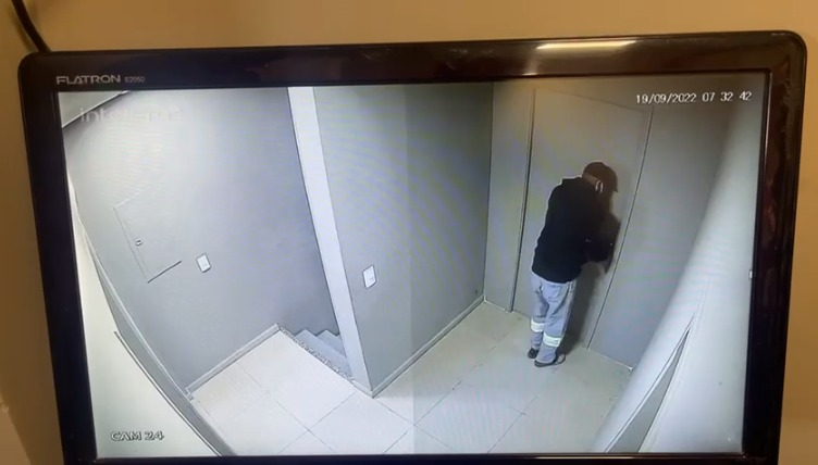 Momento em que o autor do crime simula arrombar a porta do escritório do posto Câmera de segurança