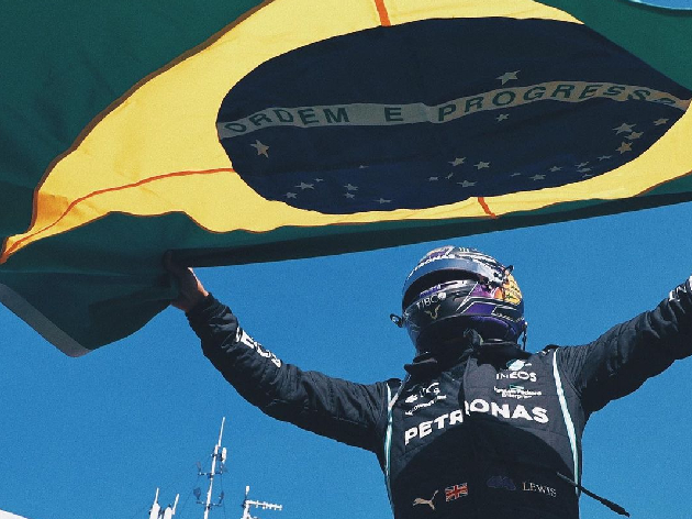 Hamilton celebrando a vitória em Interlagos com a bandeira do Brasil