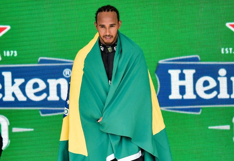 Hamilton enrolado na bandeira do Brasil após vitória em Interlagos