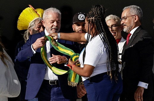 Aline Sousa entrega a faixa para Lula Adriano Machado/Reuters