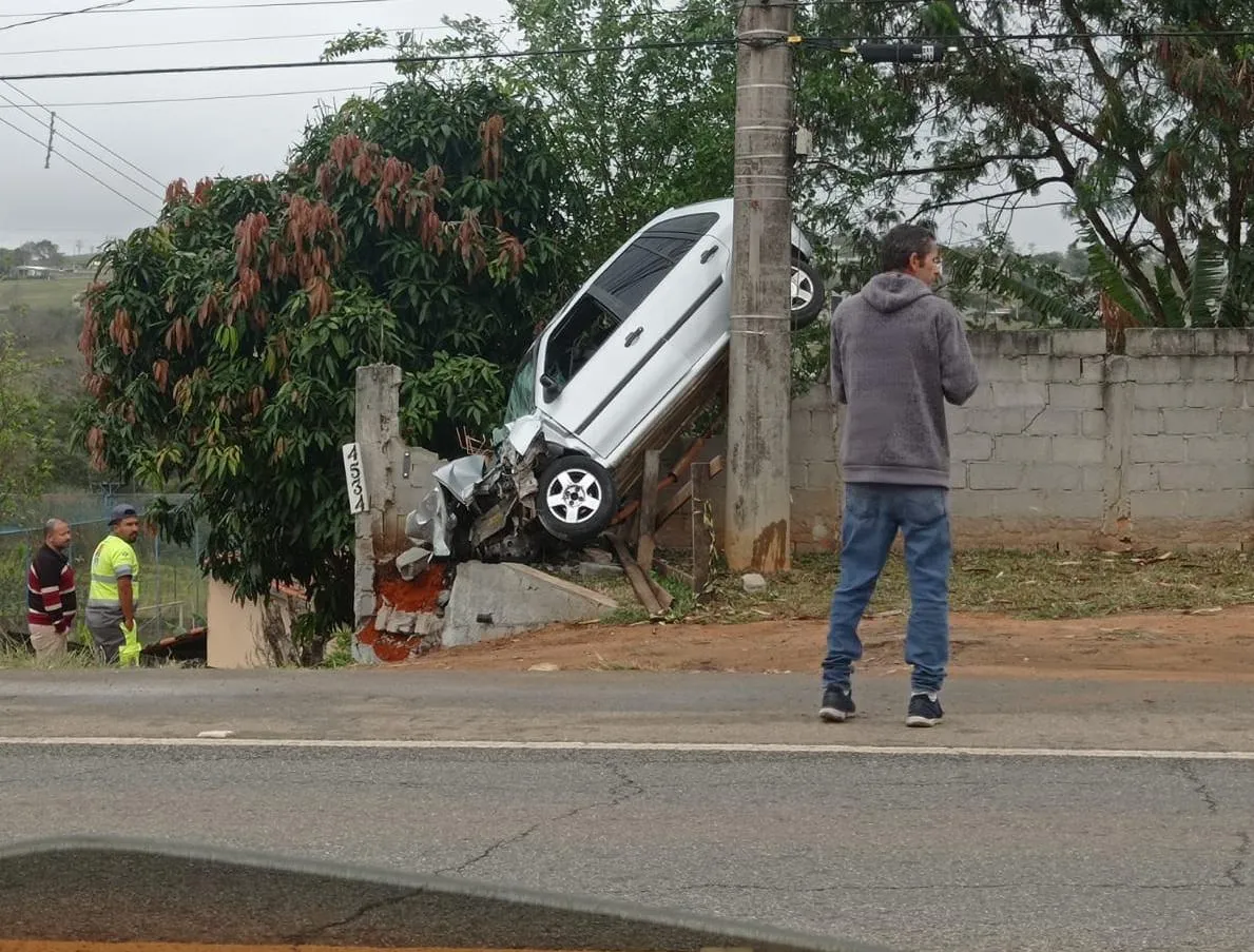 Carro parou em um muro de um imóvel ao lado da rodovia