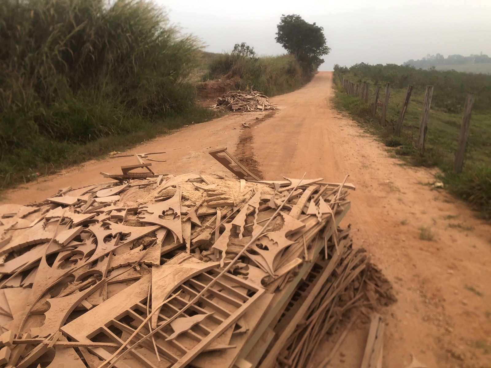 Placas e recortes de MDF que foram descartados irregularmente no meio da estrada Divulgação/GCM