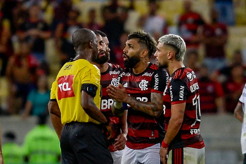 Gabigol e Arrascaeta reclamam com o árbitro Luiz Flávio de Oliveira na partida de ida