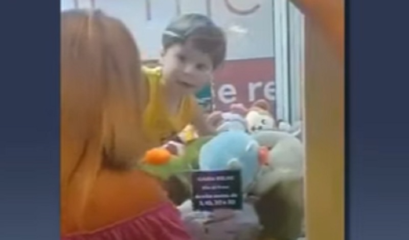 Criança viraliza após ficar presa em máquina de “caçar” pelúcias