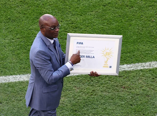 Roger Milla com a placa que recebeu da FIFA